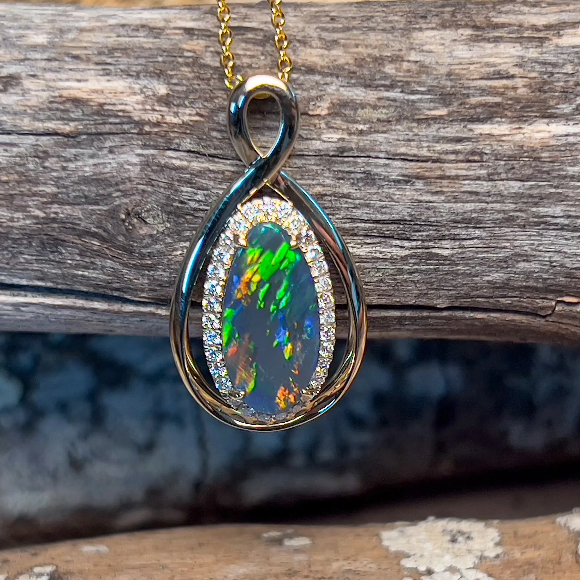 14kt Yellow Gold Infinity design Black Opal pear shape and diamond halo pendant